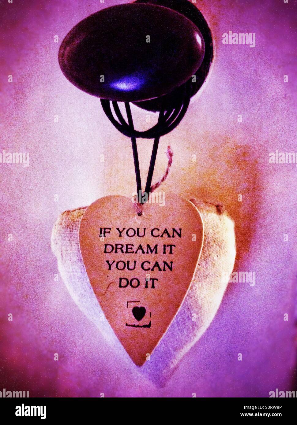 A heart shaped sentiment hanging from a door handle. - Smartphone Captured Stock Image