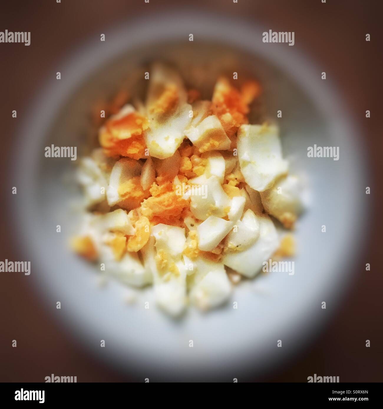 Hard boiled eggs, mixed with mayonnaise and seasoning in a bowl for breakfast - Smartphone Captured Stock Image