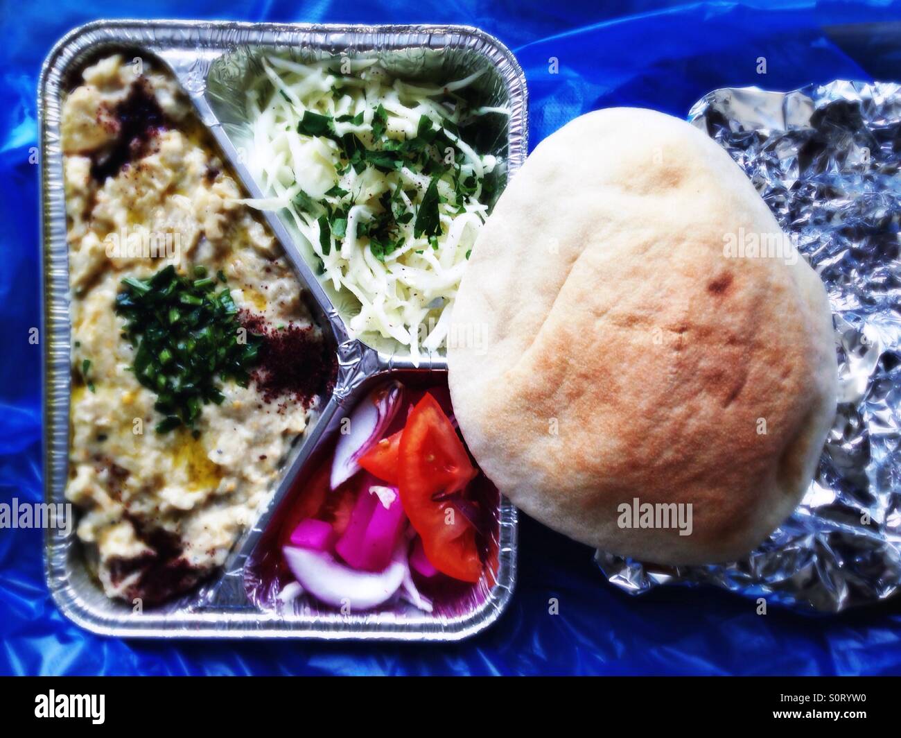 The arab appetizer dish baba ganoush in takeaway packaging with a pita bread - Smartphone Captured Stock Image