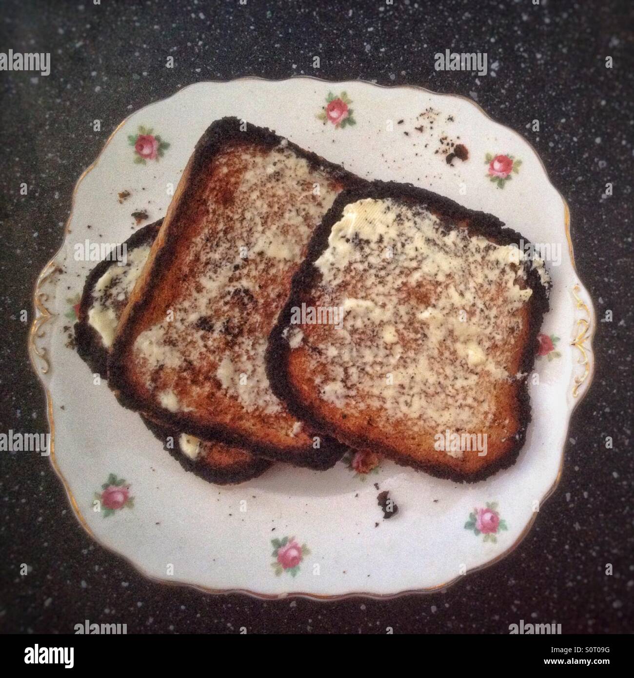Burnt buttered toast on a decorative plate Stock Photo Alamy