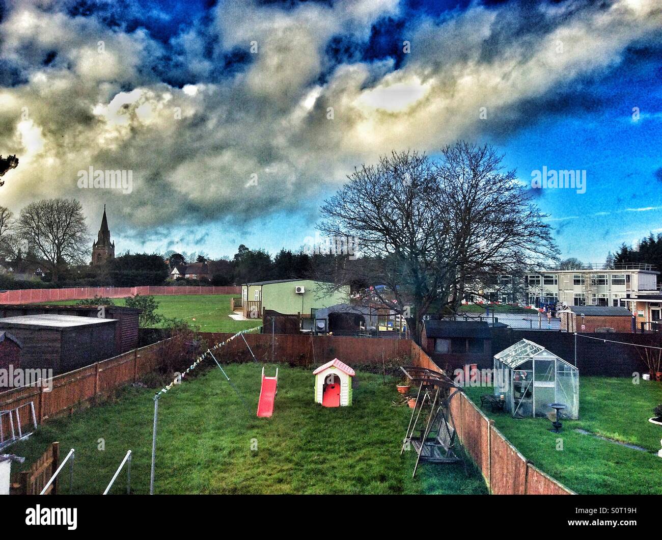 Looking out an upstairs window at the back garden and the school playing fields beyond. - Smartphone Captured Stock Image