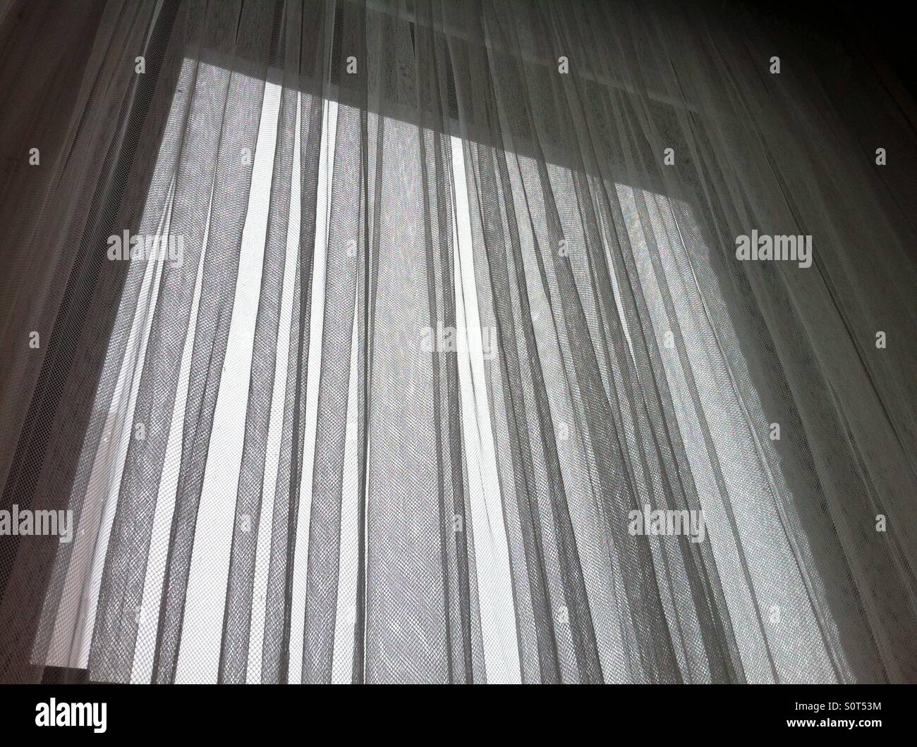 Winter blizzard, outside light through sheer curtains. Stock Photo