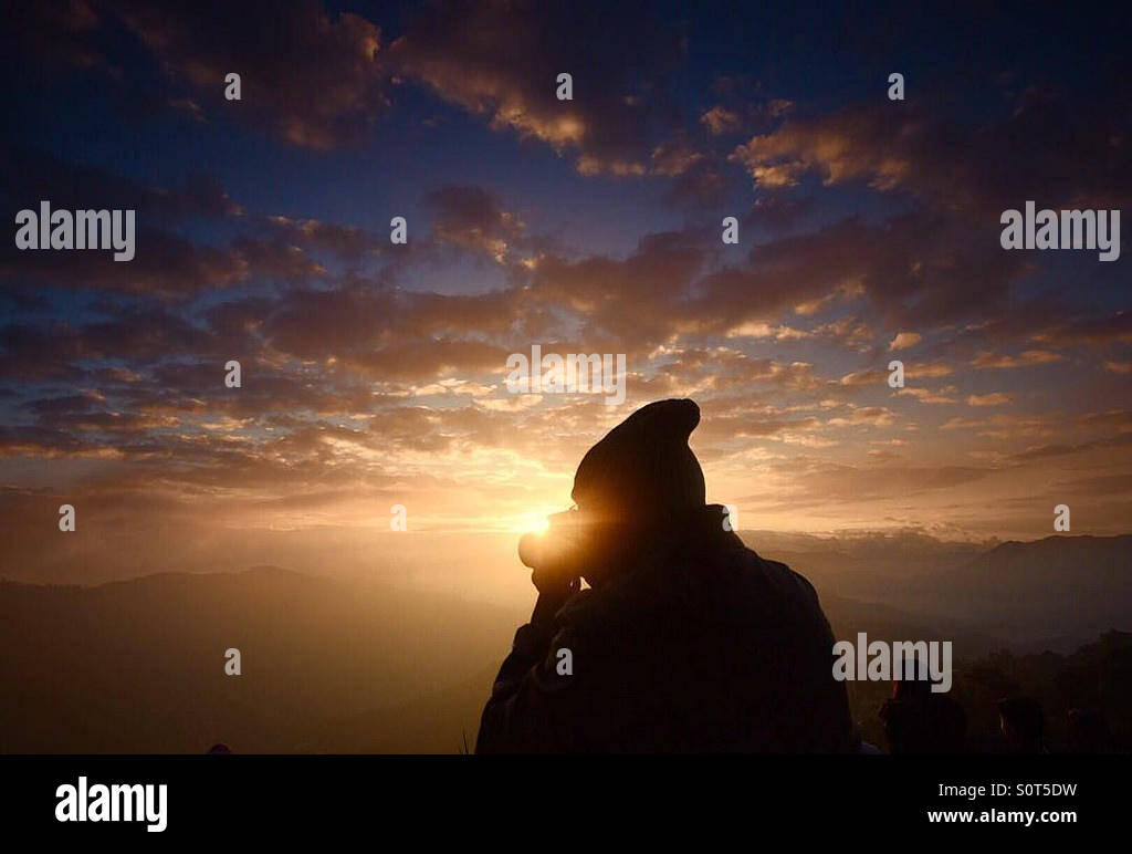 Photographer busy taking a photograph of a sunrise. Stock Photo