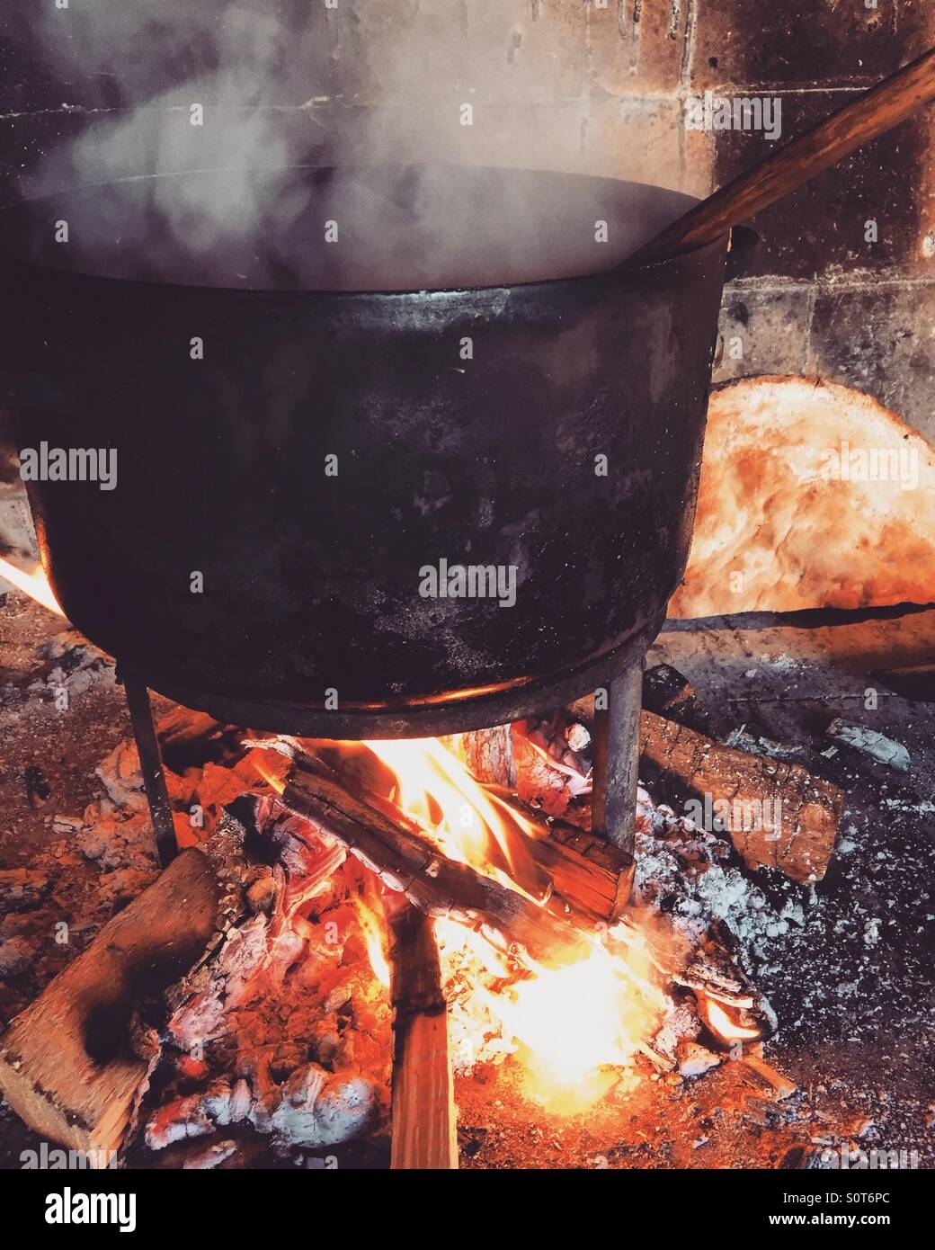 Cooking in old pot over fire Stock Photo