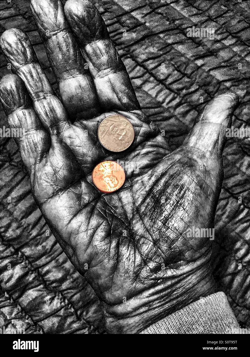 A nickel and a penny in color held in a black and white rendered palm of hand. Selective color. - Smartphone Captured Stock Image