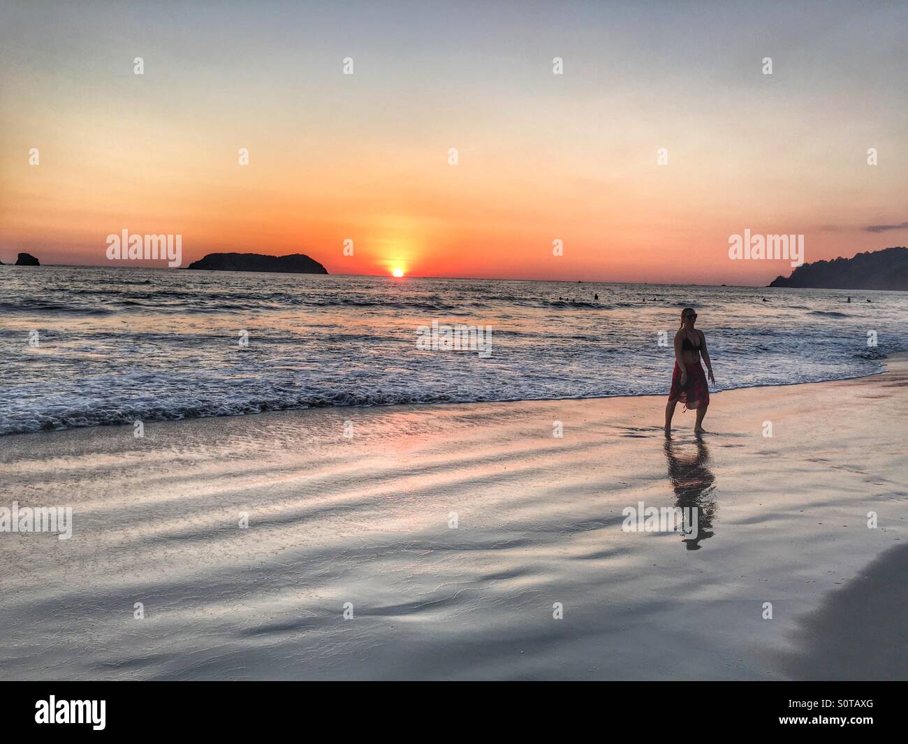 Costa Rican beach at sunset with silhouetted figure Stock Photo