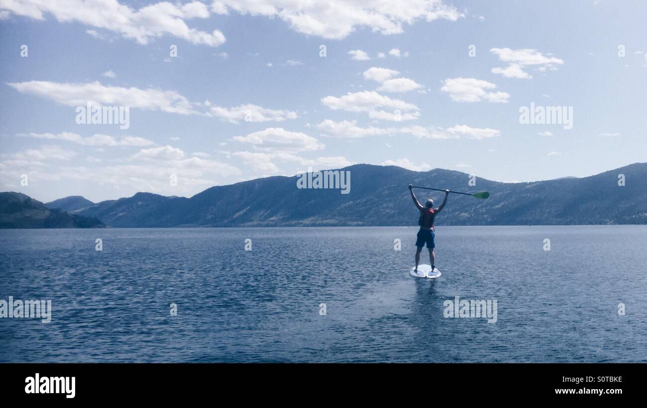 Stand up paddling in the middle of a lake in Canada Stock Photo