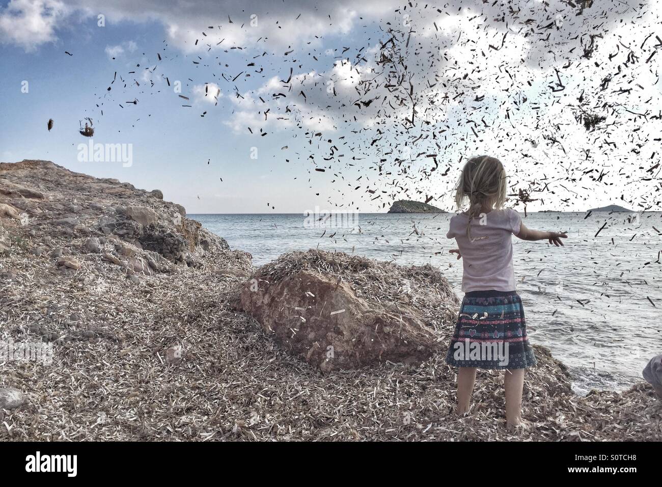 Girl throwing seaweed Stock Photo