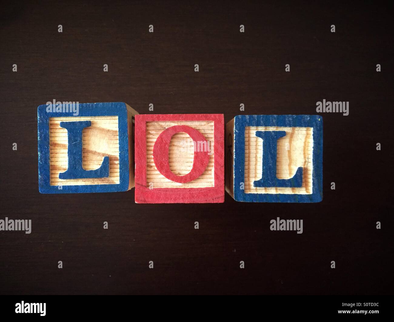 ABC Wood blocks used to spell the abbreviation LOL, laughing out loud Stock Photo
