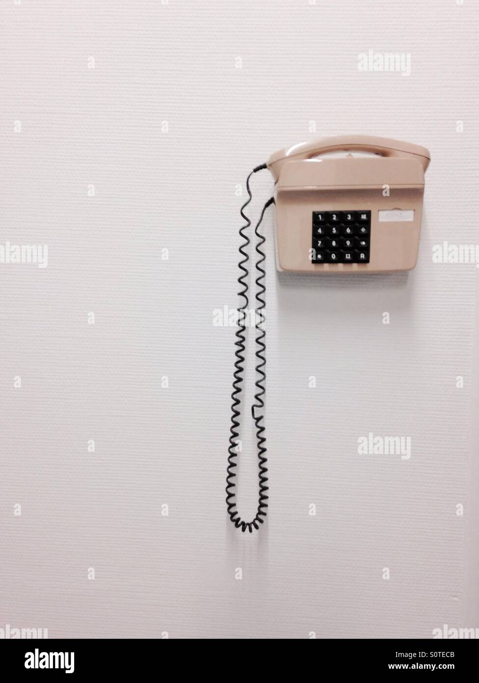 Old fashioned landline phone on a white wall Stock Photo