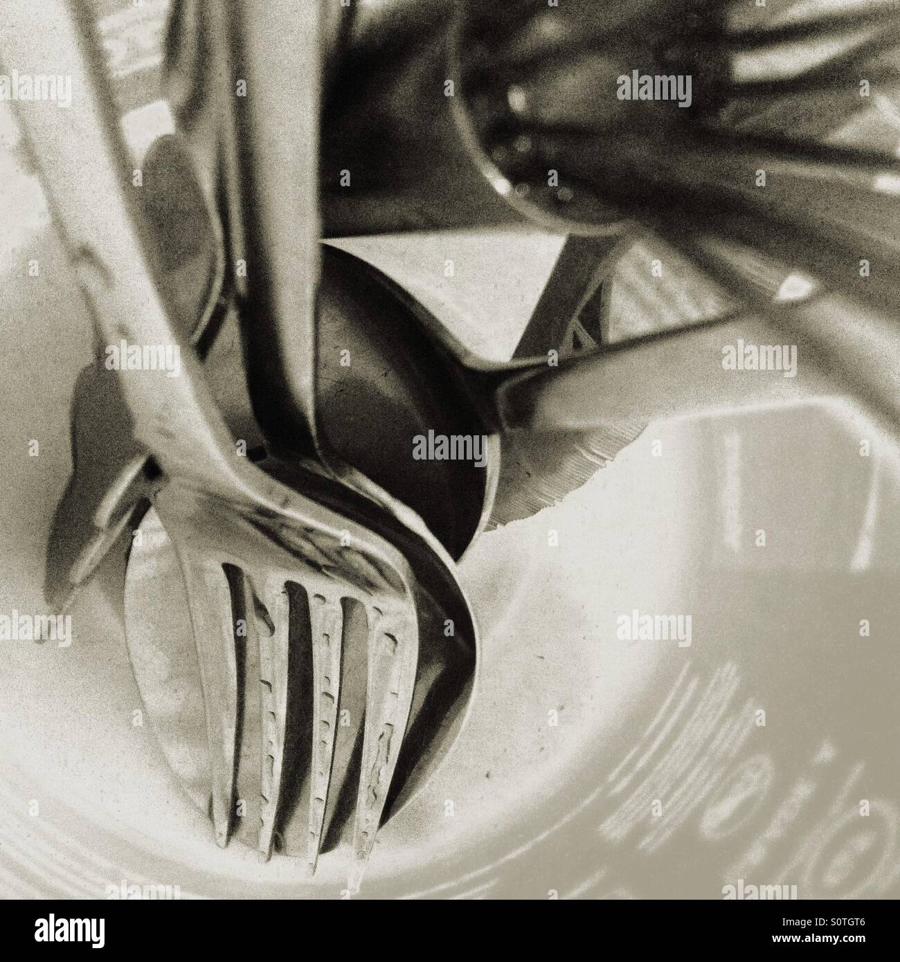 Fork, spoons, serrated knife, and whisk dripdrying Stock Photo Alamy