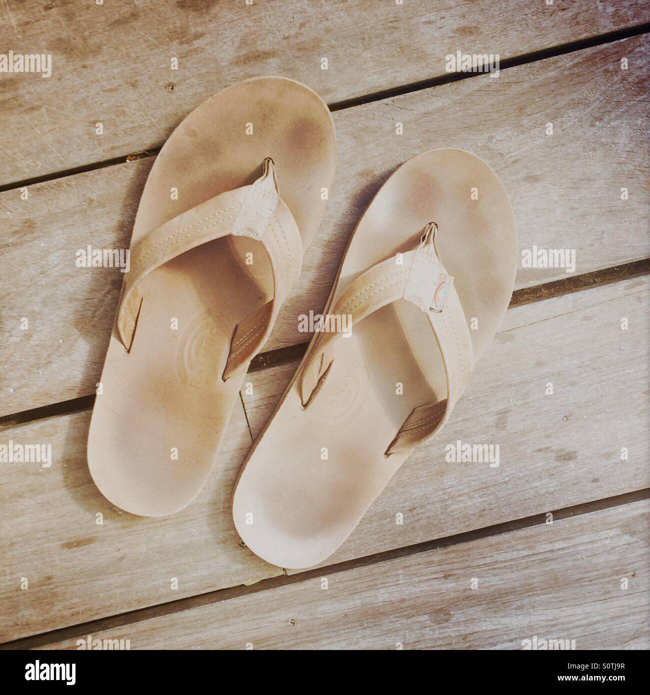 A pair of men's sandals on a wood deck. Kauai Hawaii USA. - Smartphone Captured Stock Image