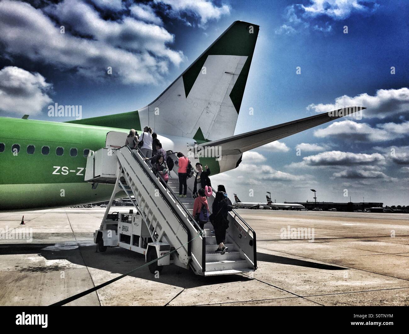 Airplane passengers embarking outside on the tarmac, OR Tambo International Airport. Stock Photo