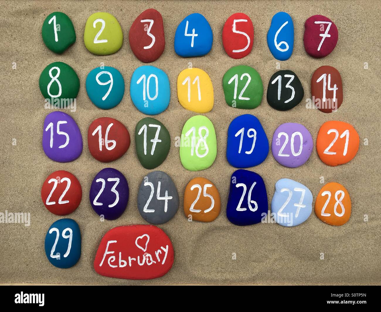 February calendar on colored stones over the sand - Smartphone Captured Stock Image