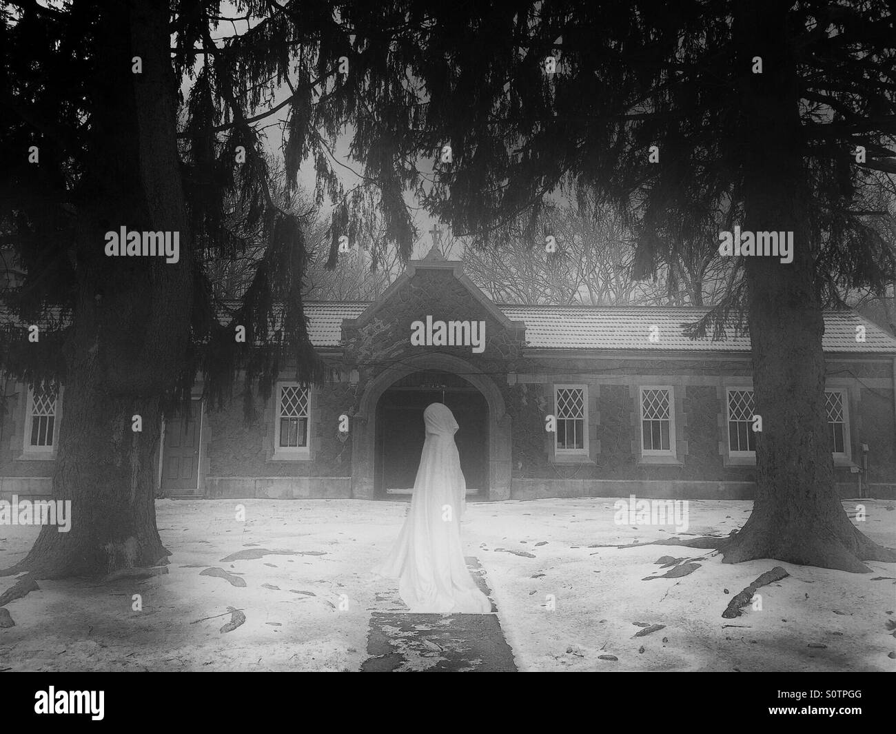 Black and White photo With Cloaked Figure at Old Monestary Stock Photo