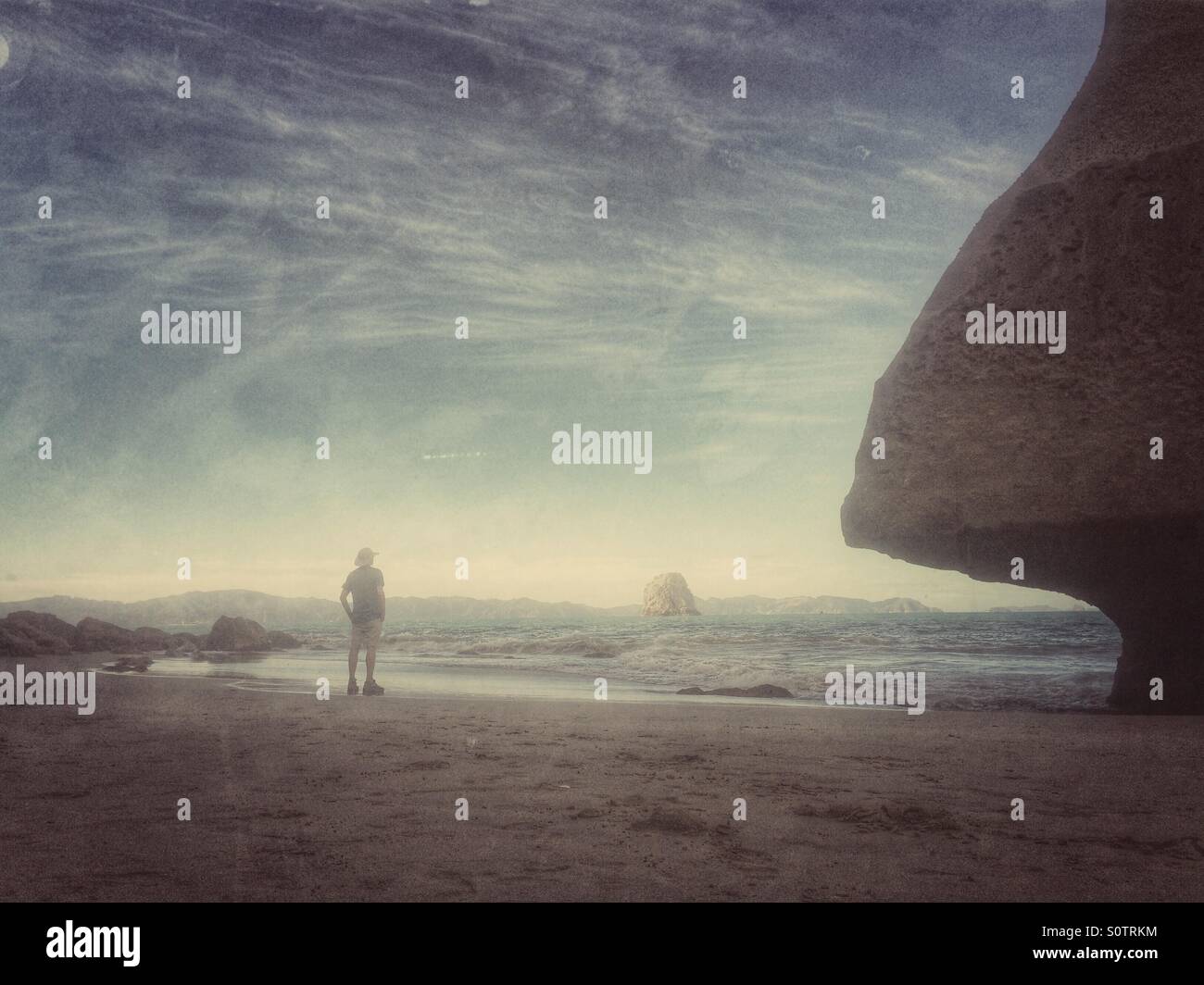 Man standing in Cathedral Cove, Coromandel, North Island, New Zealand - Smartphone Captured Stock Image