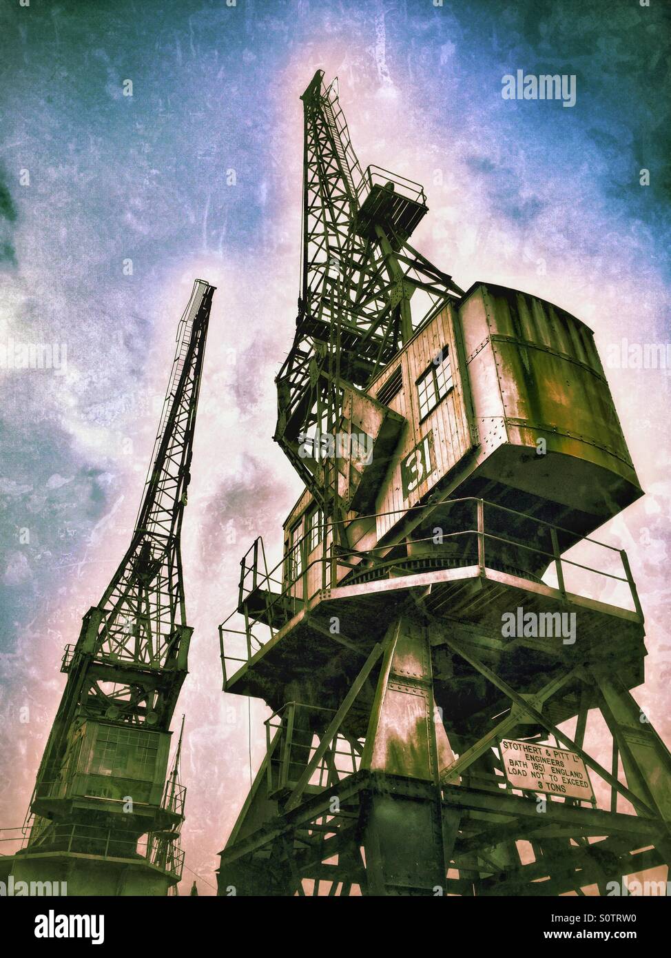 Two of the Large Cranes situated on the edge of The Floating Harbour, close to the City Centre of Bristol, England. The Cranes were used to offload cargo from ships. Photo Credit  - © COLIN HOSKINS. - Smartphone Captured Stock Image