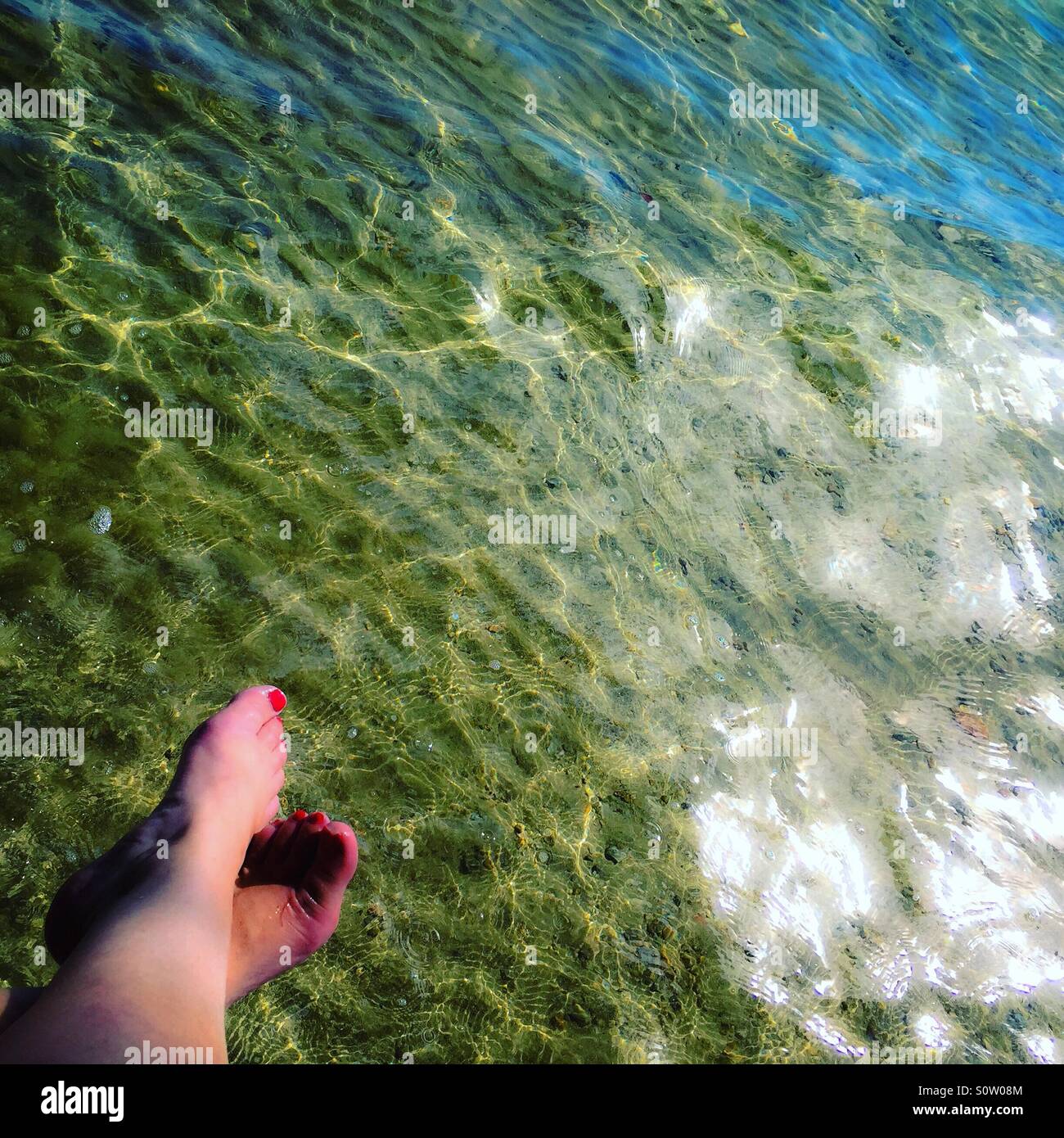 Toes above clear sparkling sea of the Mediterranean - Smartphone Captured Stock Image