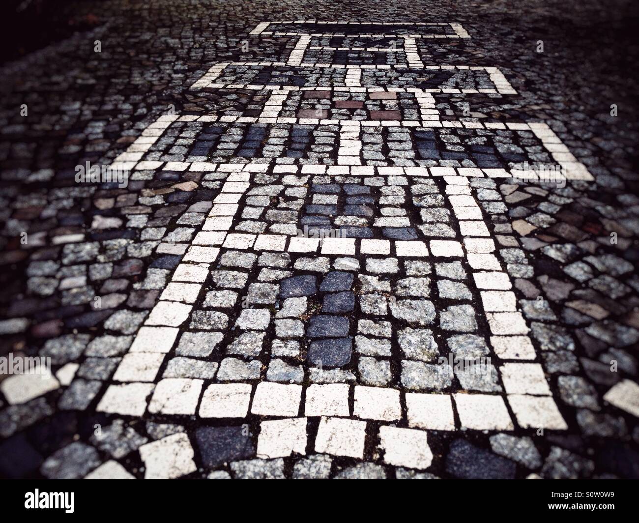 Hopscotch game integrated into the pavement of a sidewalk - Smartphone Captured Stock Image