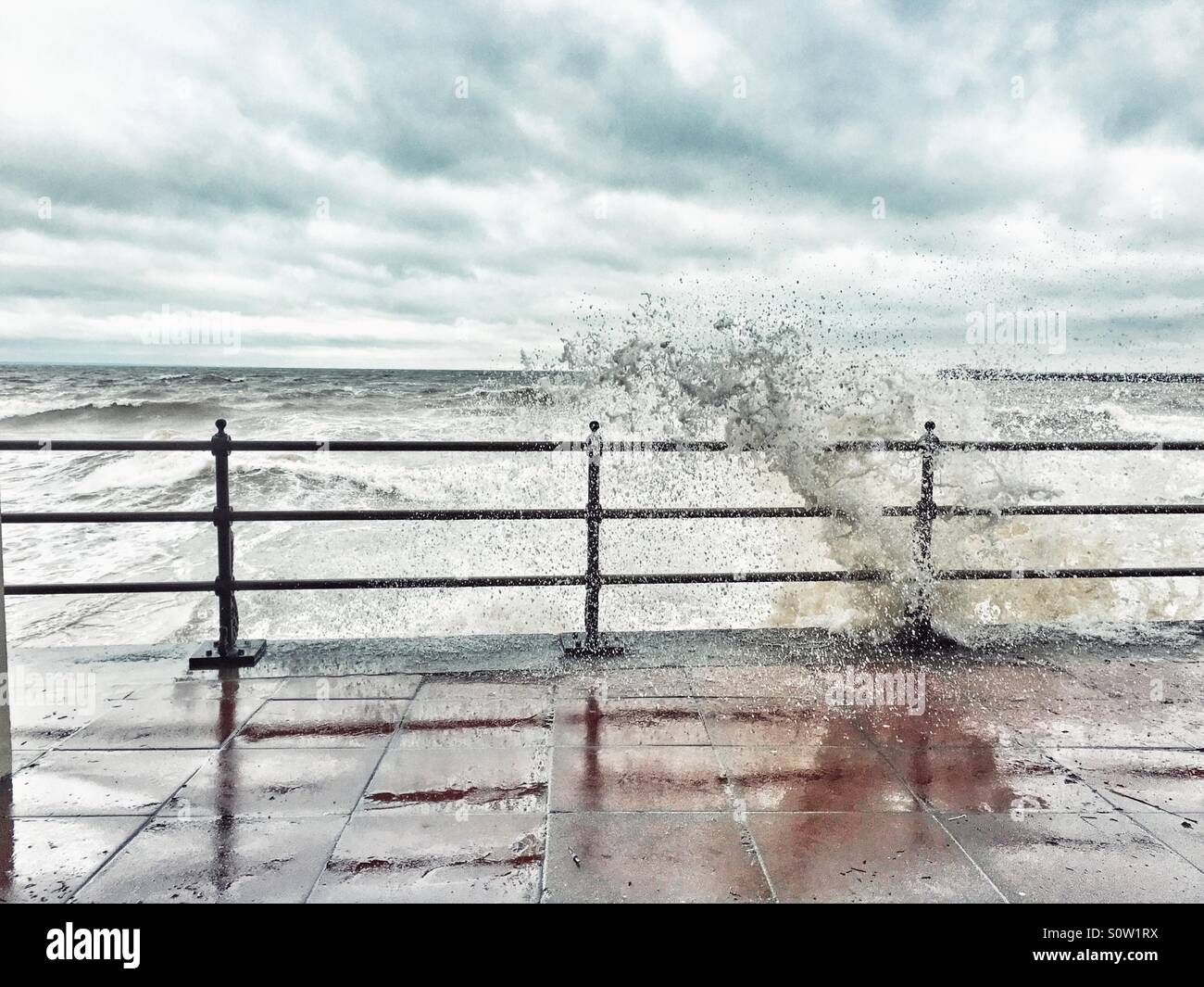 Stormy waves crash over barrier at Swanage Dorset at high tide - Smartphone Captured Stock Image