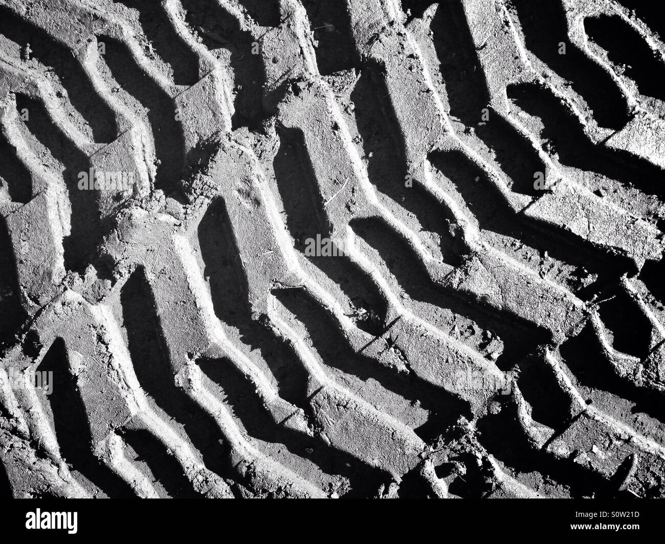 Pattern in the mud created by caterpillar tracks Stock Photo