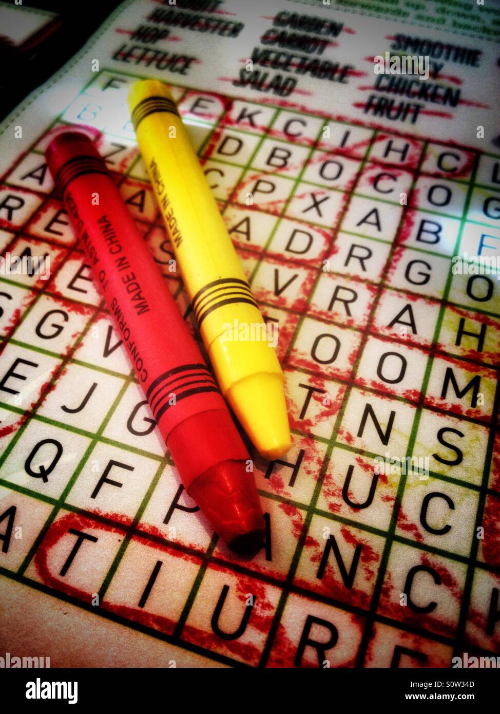 A couple of wax crayons on a word search. - Smartphone Captured Stock Image