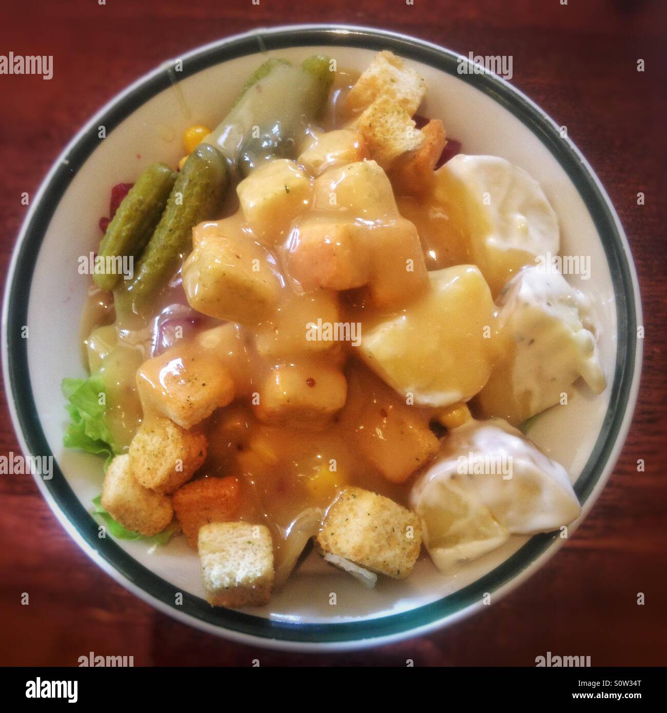 A salad covered in honey mustard sauce. - Smartphone Captured Stock Image