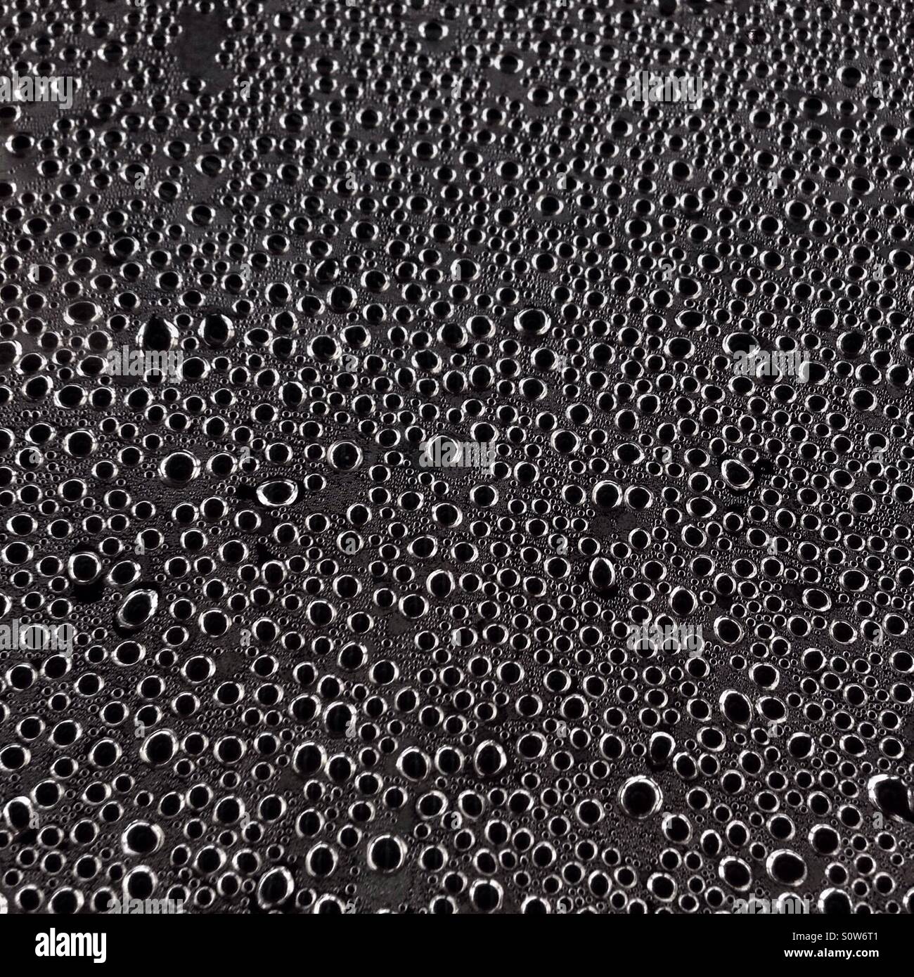 Water condensation droplets on a sheet of glass. - Smartphone Captured Stock Image