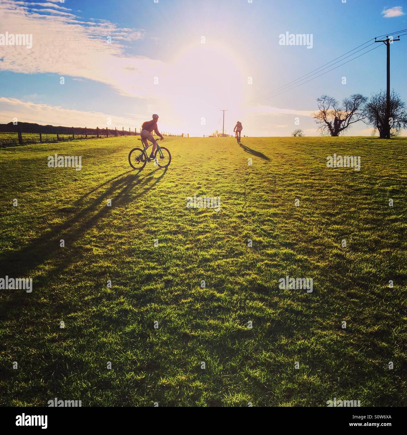 Cycling uphill into sunshine Stock Photo