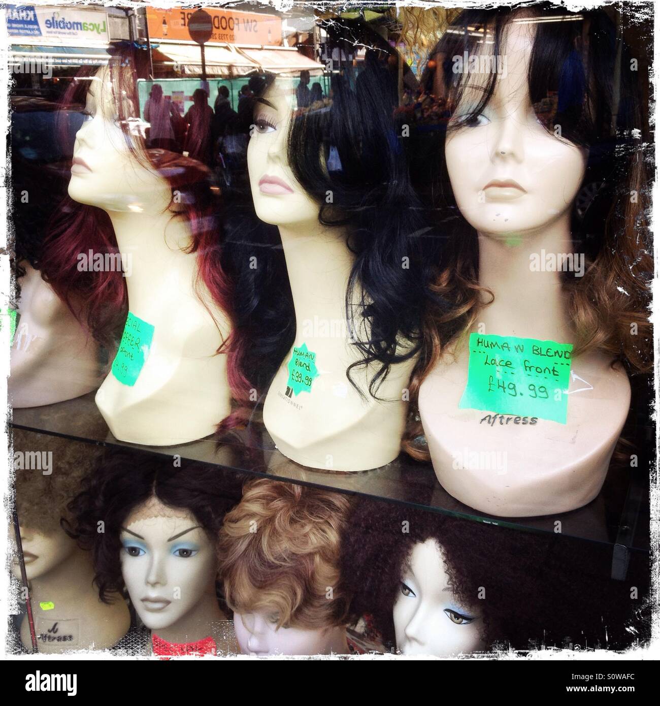 Wigs for sale in a Brixton shop window - Smartphone Captured Stock Image