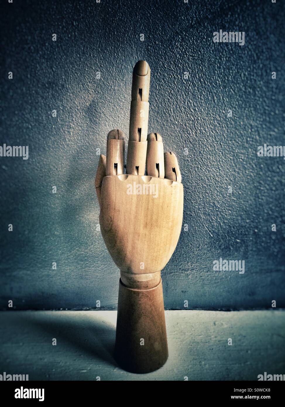 Wooden mannequin hand giving the finger Stock Photo