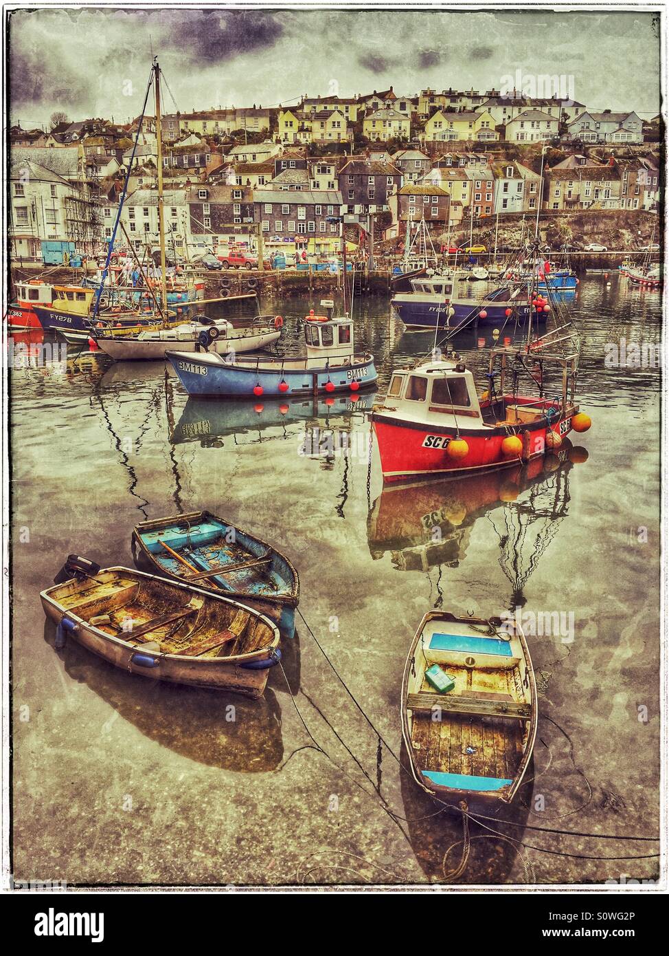 A Grunge Effect Picture of Boats in Mevagissey Harbour, Cornwall, England. A typical English Harbour Town view. Photo Credit - © COLIN HOSKINS. - Smartphone Captured Stock Image