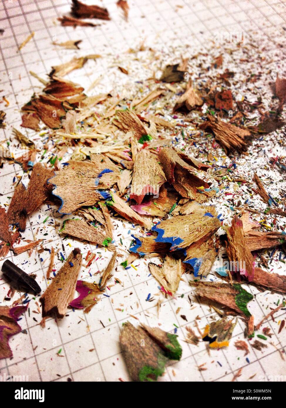 Colouring pencil shavings on a checkered sheet of paper - Smartphone Captured Stock Image