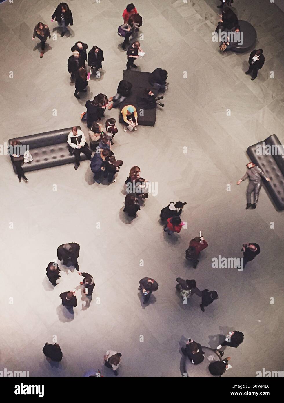 People standing in museum atrium with interactive art exhibit shot from above - Smartphone Captured Stock Image
