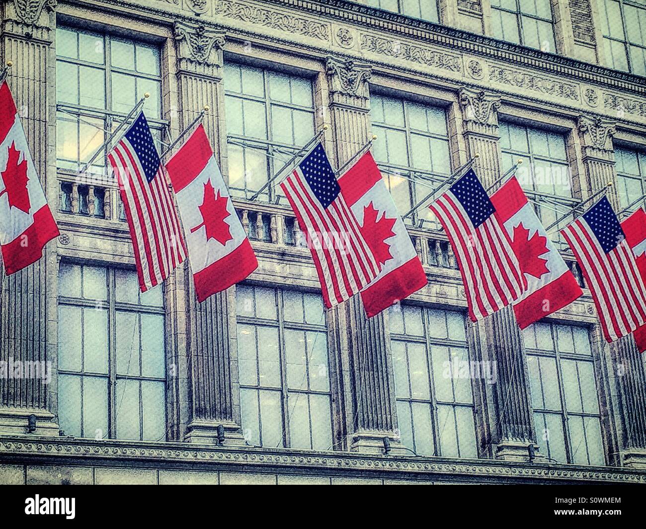 United States and Canadian flags outside of Saks fifth avenue in NYC Stock Photo