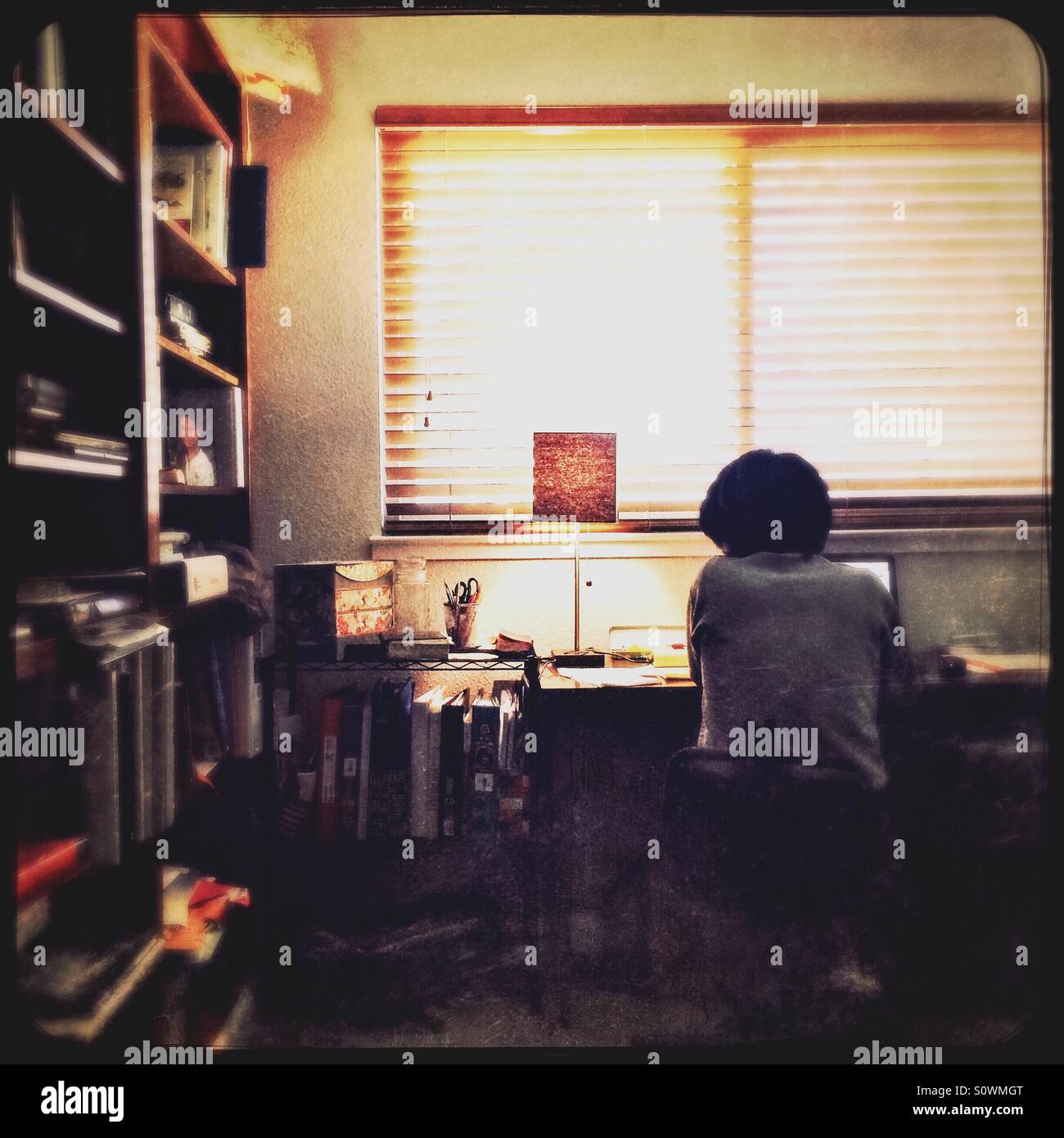 An Asian woman works from home in her office. - Smartphone Captured Stock Image