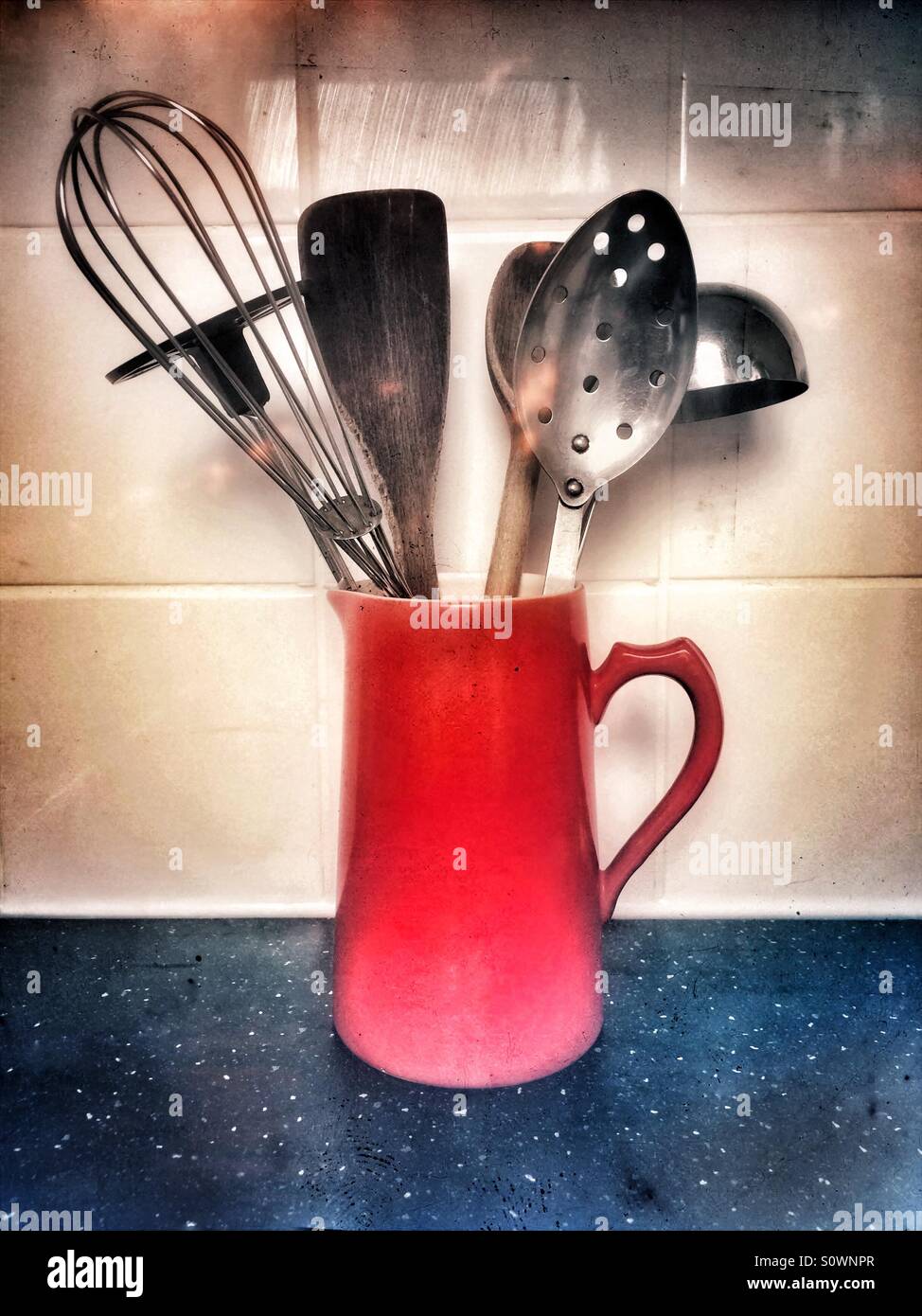 A red jug filled with kitchen utensils Stock Photo Alamy