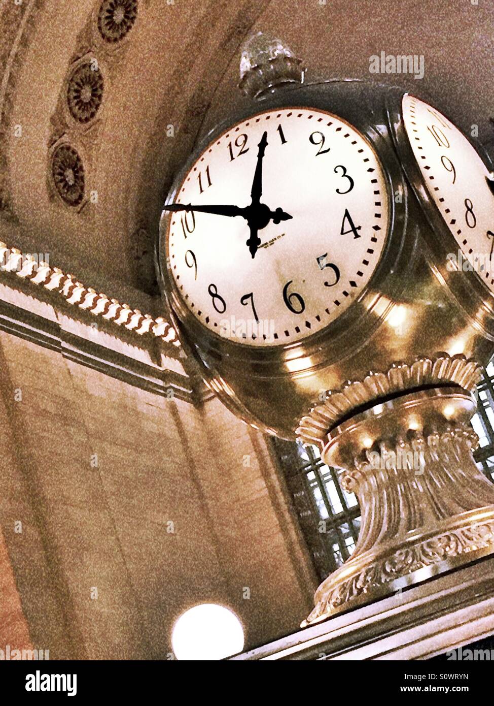 The four sided ornate clock dominates the concourse at Grand Central terminal, NYC Stock Photo