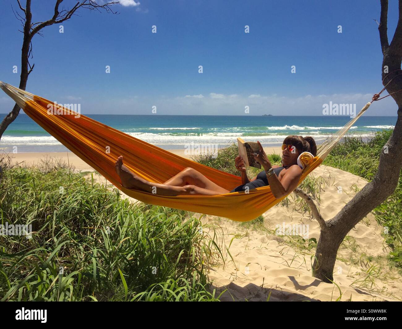 Woman in hammock by the sea Stock Photo
