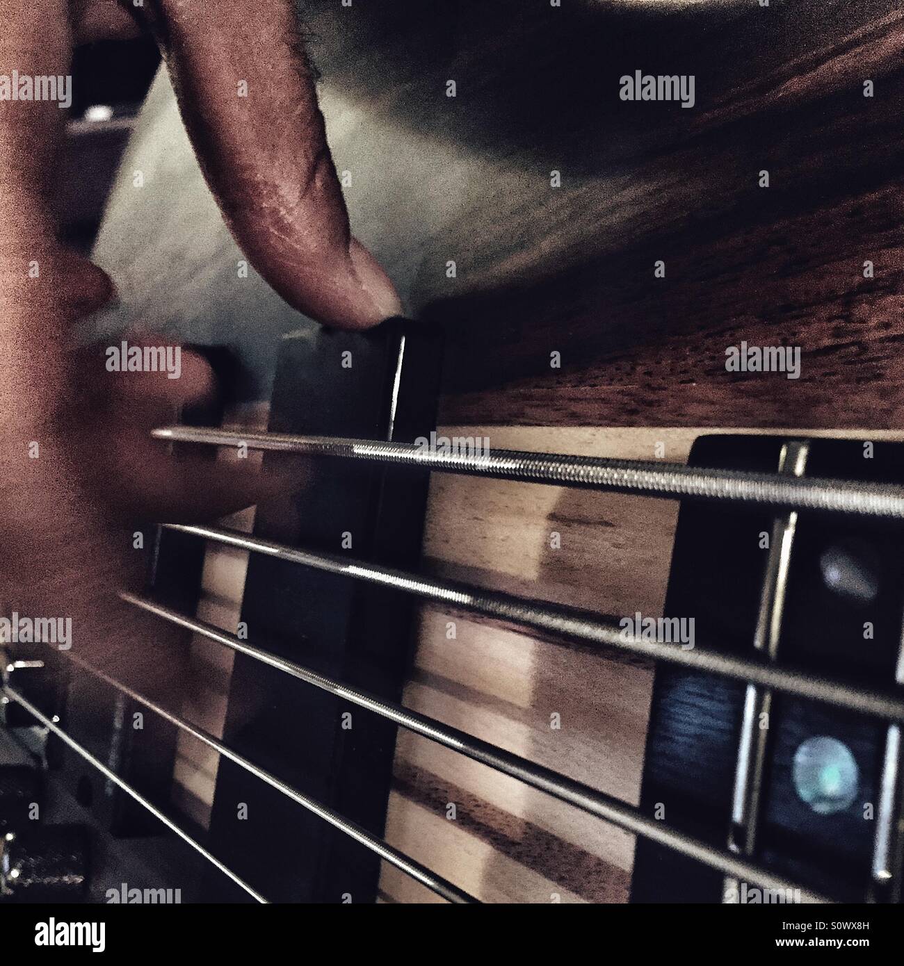 Finger picking on bass guitar Stock Photo