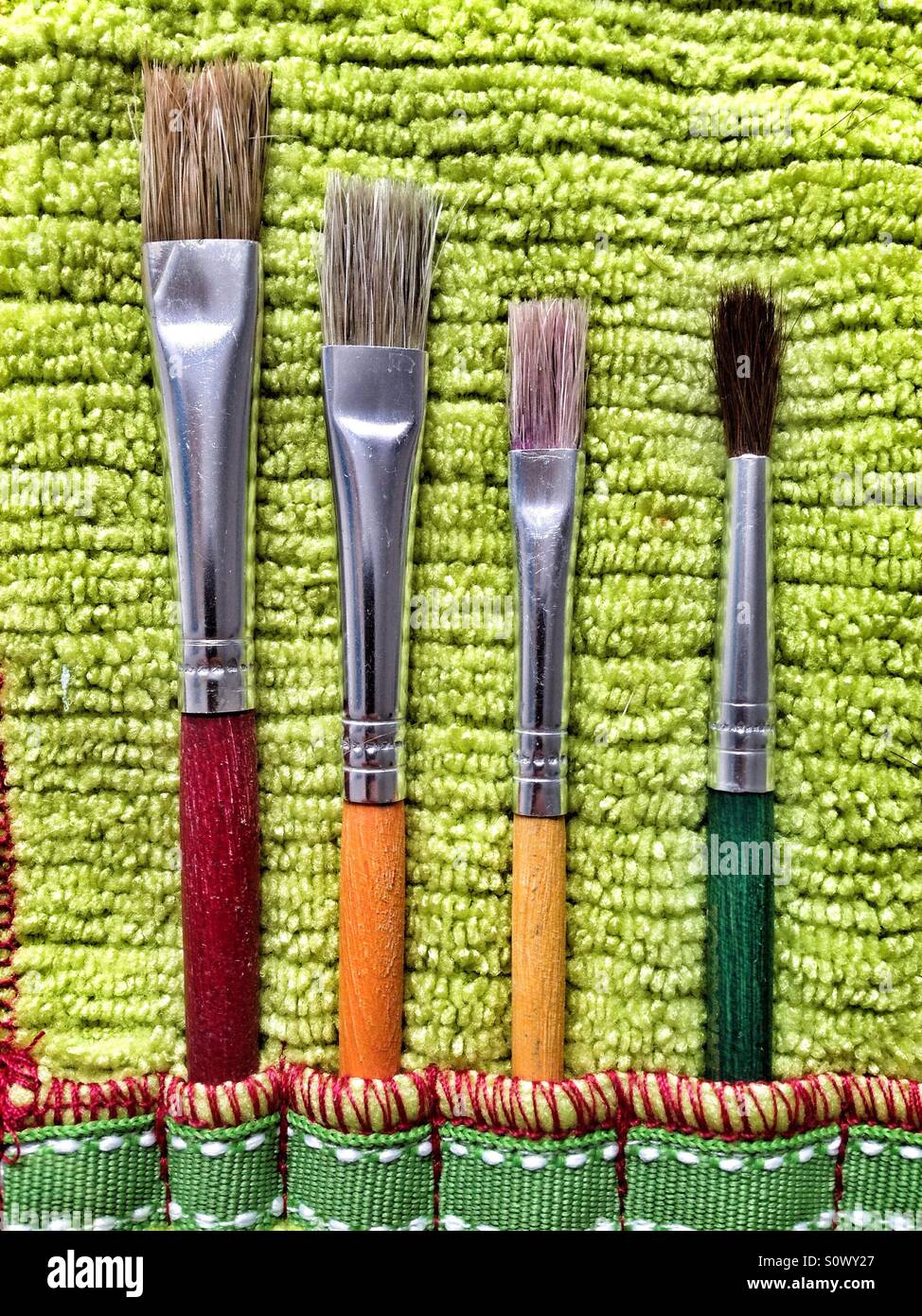 Paint brushes on soft green cloth - Smartphone Captured Stock Image
