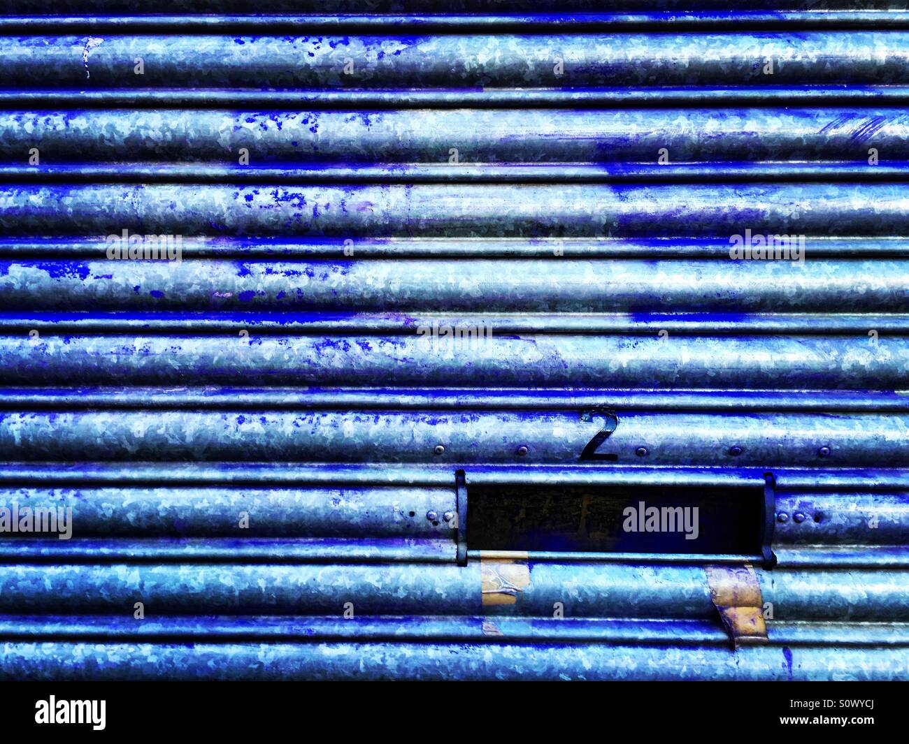 Corrugated shutter with number two over the letterbox opening. - Smartphone Captured Stock Image