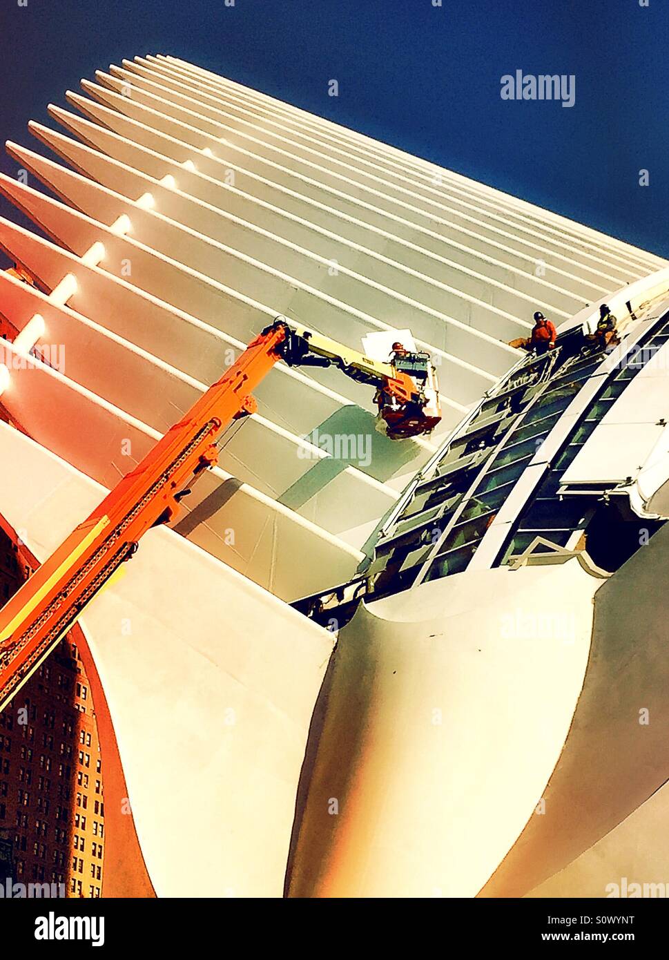 Construction workers and crane placing roof tiles on the World Trade Center transportation hub, NYC - Smartphone Captured Stock Image