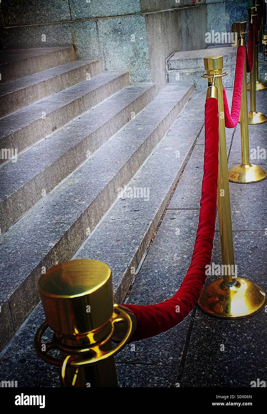 Velvet red ropes and stanchions keep an event exclusive Stock Photo
