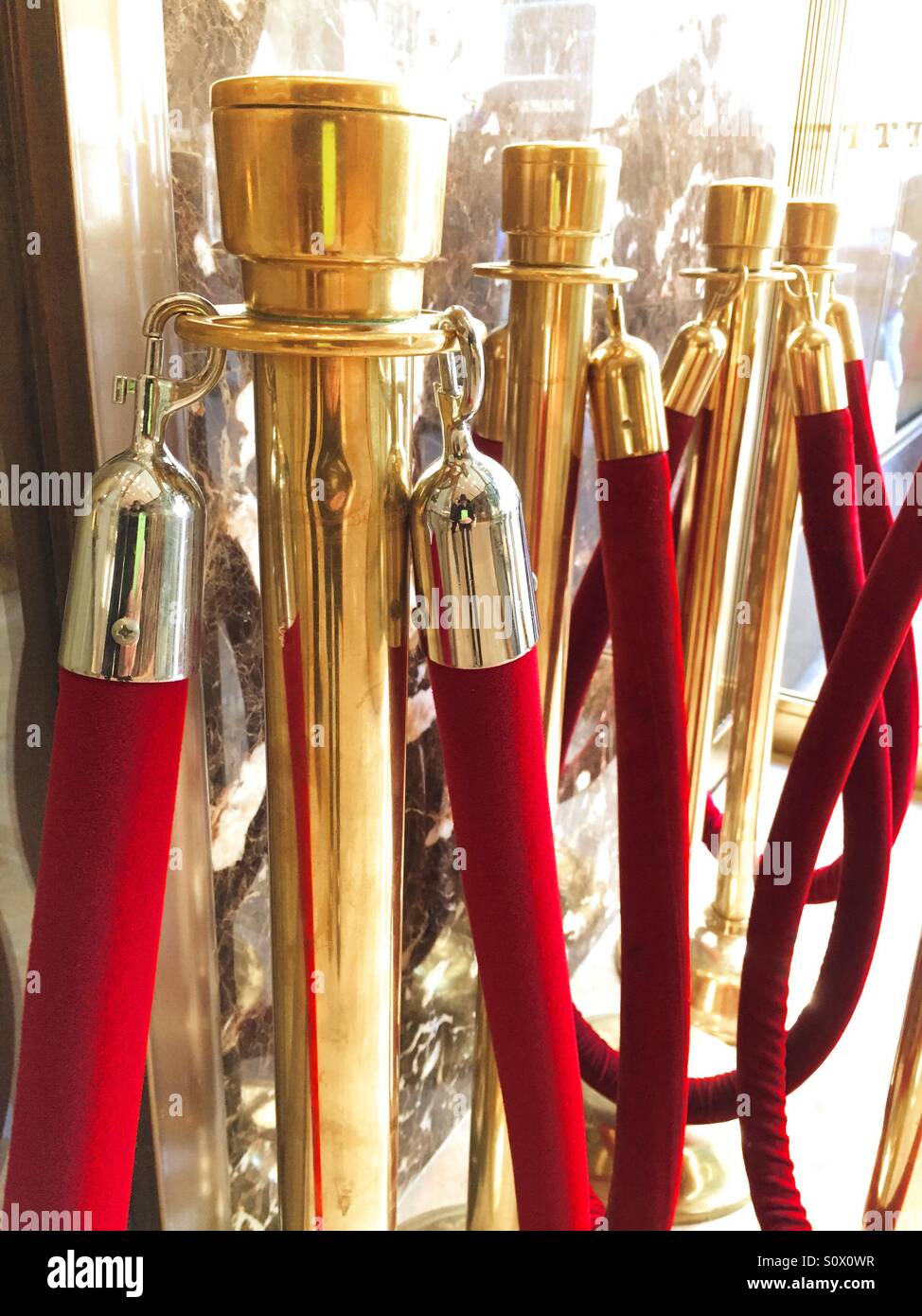 Red velvet ropes and brass stanchions signify exclusivity. Stock Photo