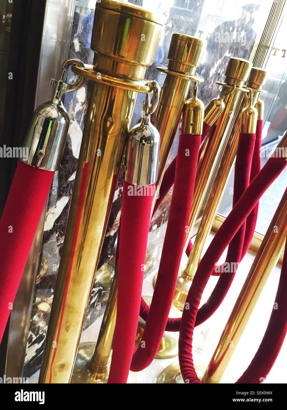 Red velvet ropes and brass stanchions signify exclusivity. Stock Photo