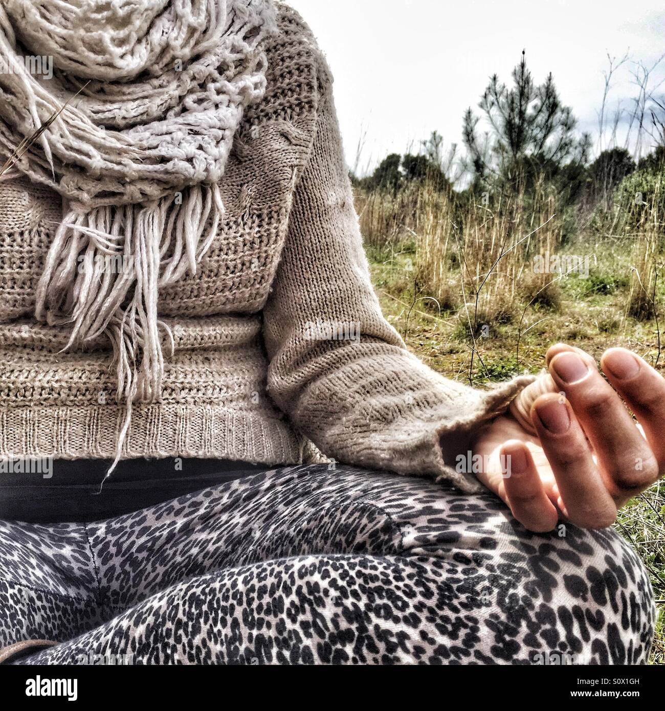 Woman meditating in a field Stock Photo