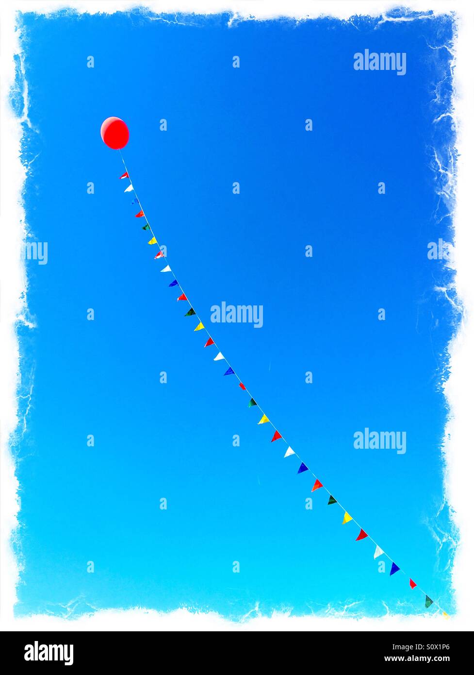 A helium filled balloon on a long rope with flags. - Smartphone Captured Stock Image
