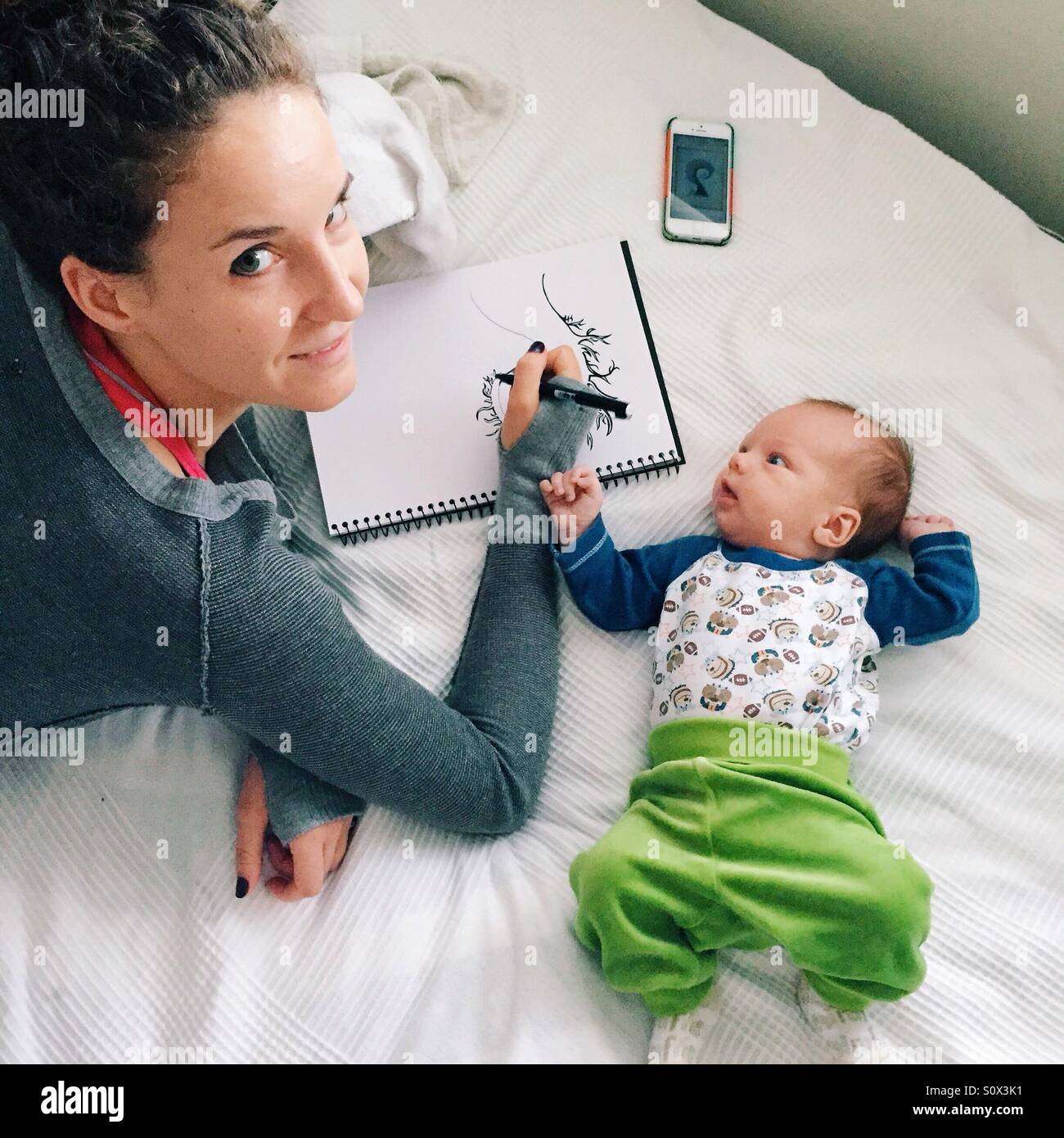 Mother sketching and baby making company Stock Photo
