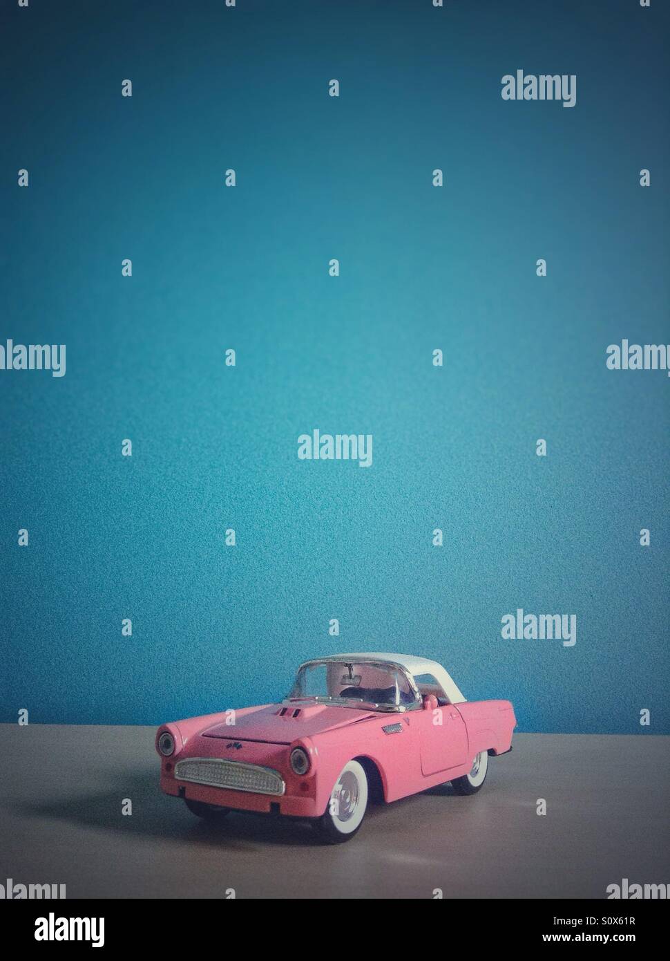 Classical pink vintage toy car on blue background Stock Photo